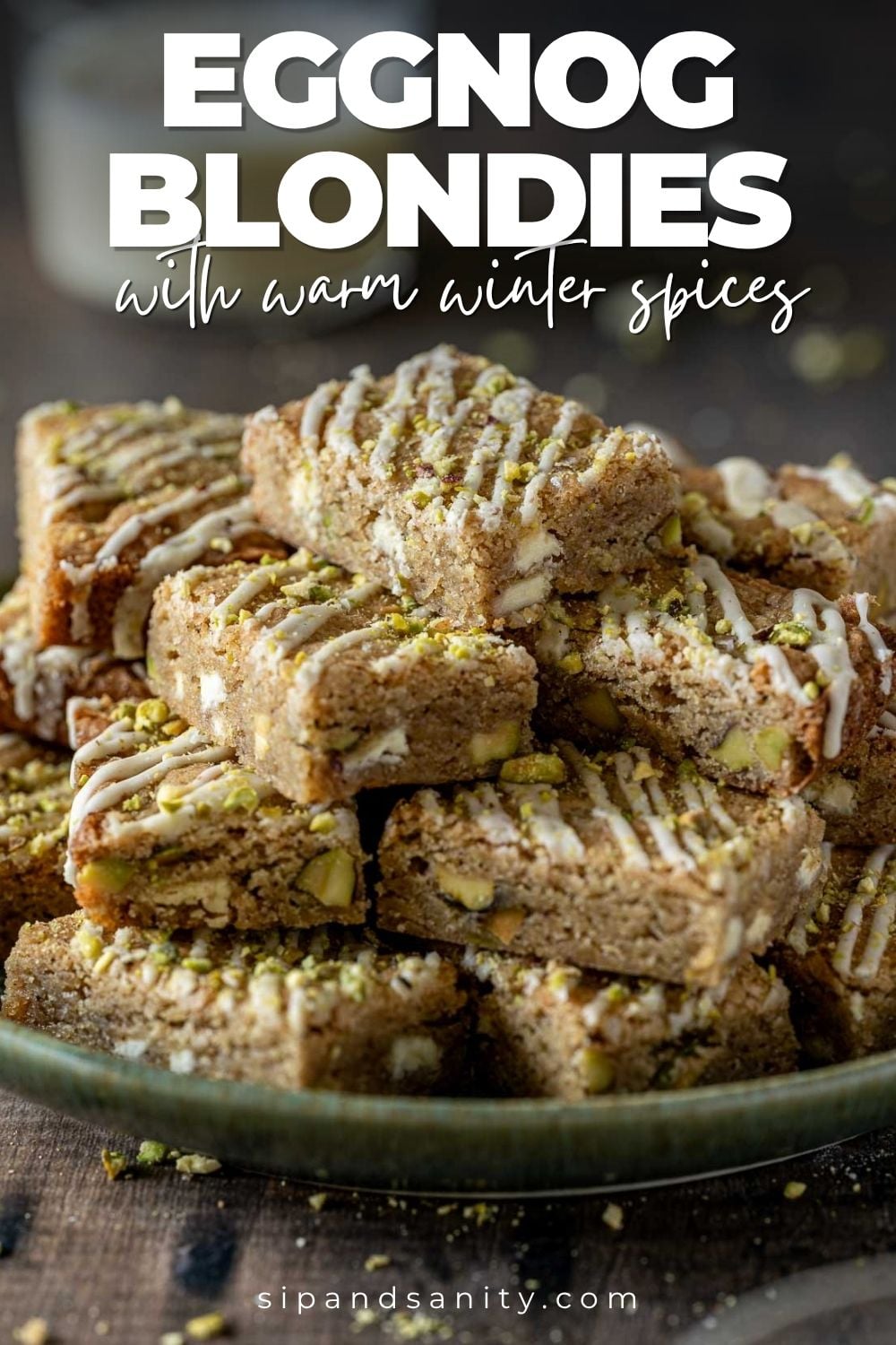 A stack of eggnog blondies with icing drizzle and crushed pistachios.