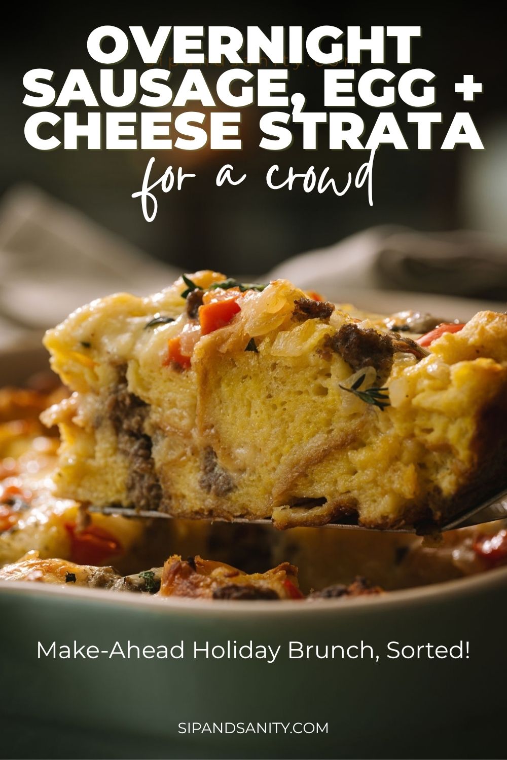 A slice of sausage, egg, and cheese strata lifted from a dish; text reads: Overnight sausage, egg + cheese strata for a crowd.