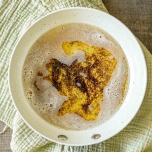 Brown butter bubbles in a white pan.
