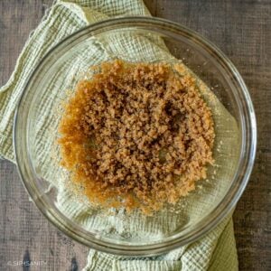 A glass bowl filled with a mixture of brown butter and sugars.